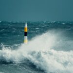A once in a decade storm hitting the iconic Cottesloe bollard. Huge waves crash against the bollard with heavy rain pouring down.
