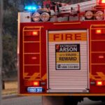 Fire truck advertising a reward for arson information.
