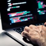 Hacker,With,Malware,Code,In,Computer,Screen.,Cybersecurity,,Privacy,Or