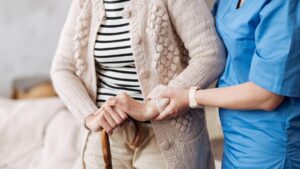 Gentle trained nurse helping mature patient