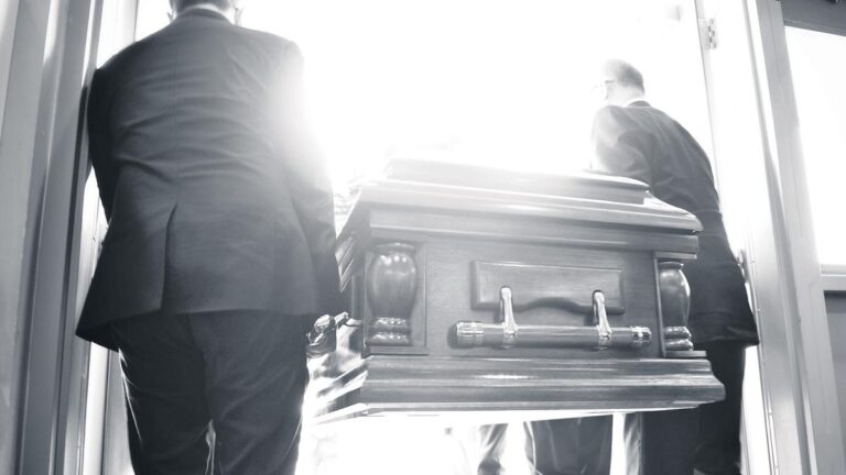 Rear View Of People Carrying Coffin