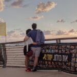 Surrounded by banners about hostages held by Hamas, a couple enjoys sunset over the Mediterranean Sea in Tel Aviv, Israel, Oct. 12, 2025. (Amit Elkayam/The New York Times)