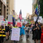 Demonstrators march through the streets of downtown despite heavy rain for the No Kings Day protests in Dallas, Texas on Saturday, Oct. 18, 2025. (Desiree Rios/The New York Times)