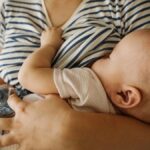 Mother's carrying toddler and breastfeeding at home