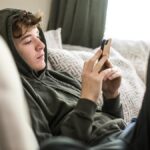 Teenage boy using smartphone at home