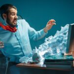 Young,Stressed,Handsome,Businessman,Working,At,Desk,In,Modern,Office