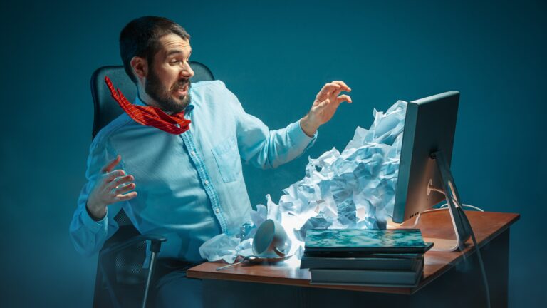 Young,Stressed,Handsome,Businessman,Working,At,Desk,In,Modern,Office