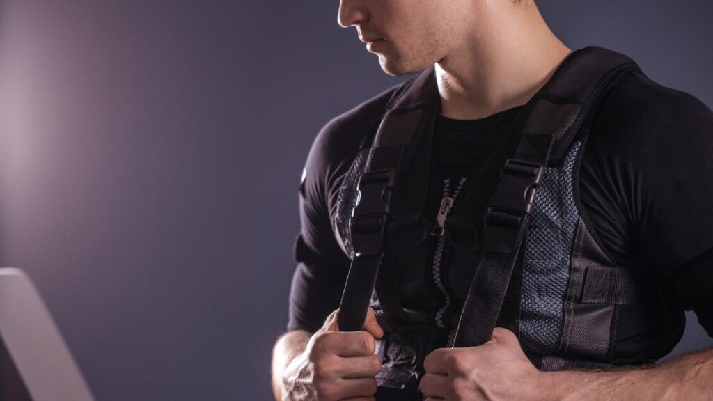 portrait of handsome man near electro muscle stimulation machine