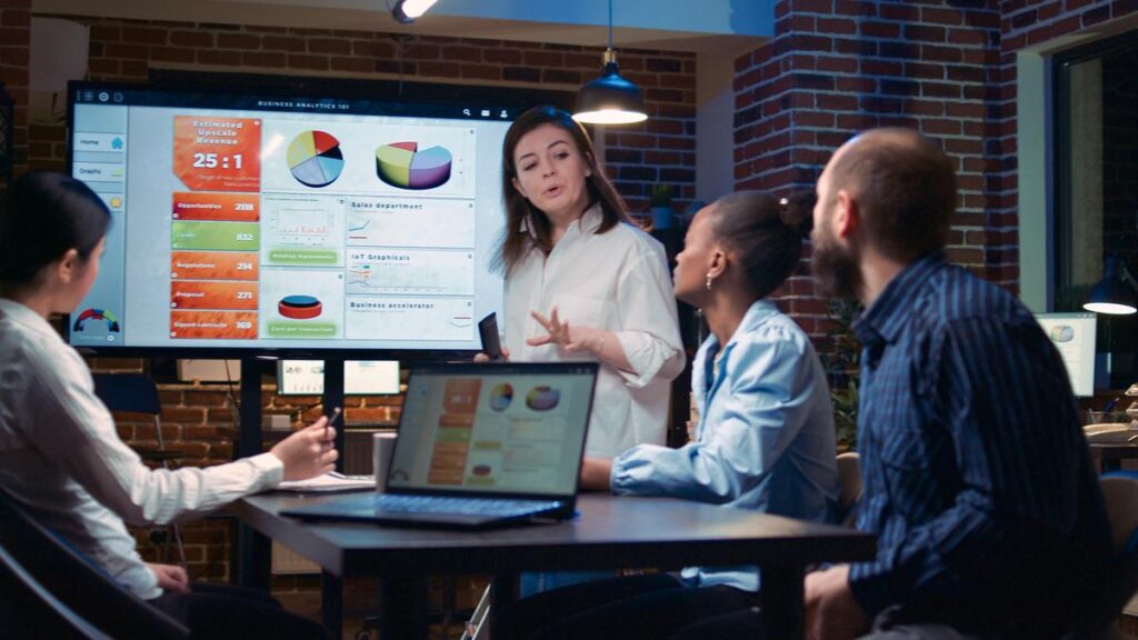 Business analytics team meeting, woman showing corporate presentation