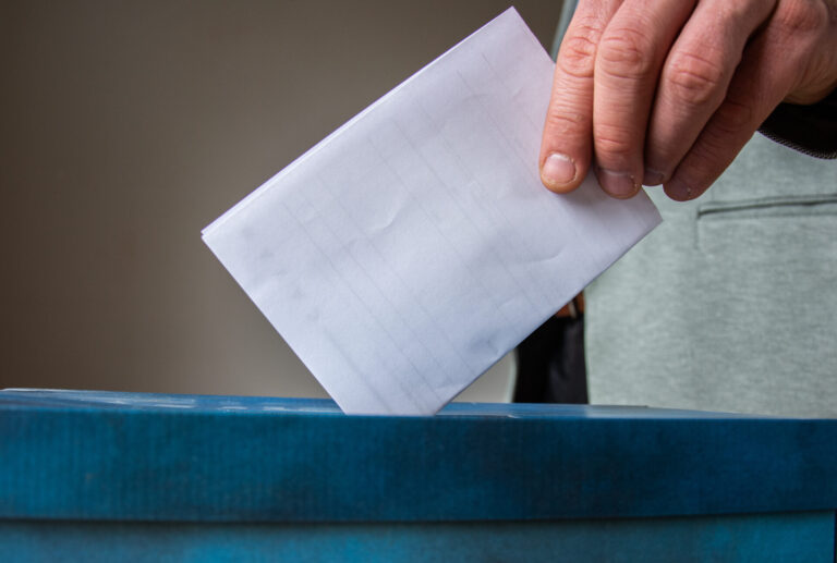 European Union parliament election concept -  hand putting ballot in blue election box