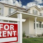 Right Facing Red For Rent Real Estate Sign in Front of Beautiful House.