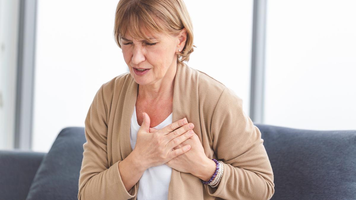 Woman with pain on heart, Mature female presses hand to chest ha