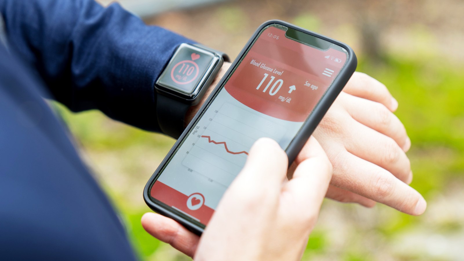 Businessman on the go checking his glucose level using a smartwatch and phone app